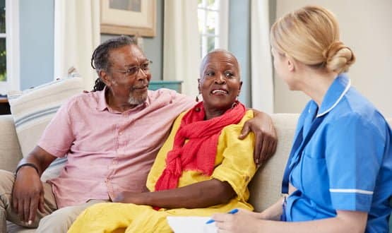 A social care nurse speaks to a couple