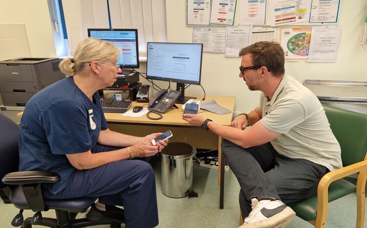 Ben Standeven, from SCALE talking to a nurse about Pocketalk